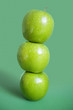 Photo: Stack of green apples over colored background Stack of green apples over colored background
