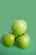 Photo: Close-up of green apples in pyramid stack over colored background Close-up of green apples in pyramid stack over colored background