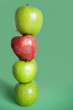 Photo: Red and green apples balancing over colored background Red and green apples balancing over colored background