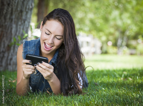 Photo: Mixed Race Young Female Texting on Cell Phone Outside Mixed Race Young Female Texting on Cell Phone Outside