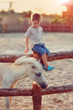 on a farm the boy in jeans with white a pony gets acquainted