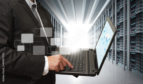 Photo: business man use notebook in server room business man use notebook in server room