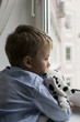 little boy with a toy near a window