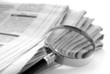 daily newspaper and a magnifying glass to find news