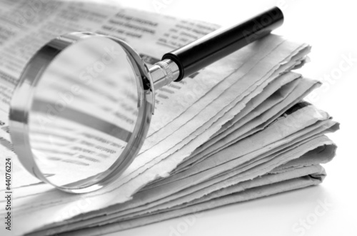 Photo: daily newspaper and a magnifying glass to find news daily newspaper and a magnifying glass to find news