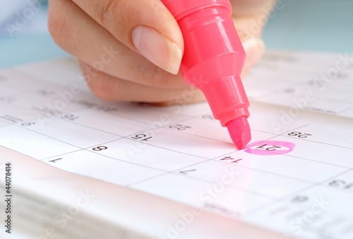 Photo: girl marker marks the date in the calendar girl marker marks the date in the calendar