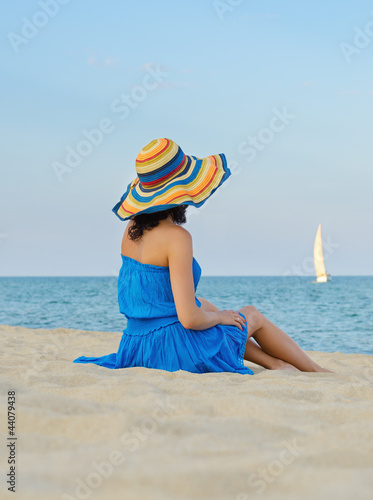 Photo: Woman with a hat on sandy beach Woman with a hat on sandy beach