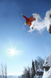 Snowboarder jumping against blue sky