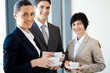 group of businesspeople having coffee during break in office