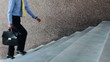 Video: Confident businessman with suitcase walking the stairs Confident businessman with suitcase walking the stairs