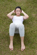 Chinese woman doing situps in park.
