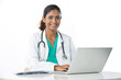 Portrait of a happy Female Doctor working on a laptop.