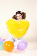 girl keeps a yellow pillow in a pajamas in the form of heart