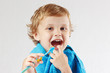 Little cute boy with toothbrush with pink toothpaste