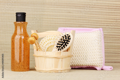 Photo: Bathroom set with scrub on bamboo background Bathroom set with scrub on bamboo background