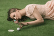 Foto: girl’s lying on grass with golf ball, she hits that girl’s lying on grass with golf ball, she hits that