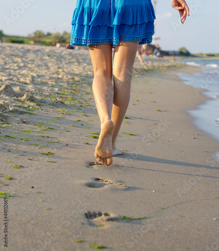 Photo: Barefoot woman walking on wet sand Barefoot woman walking on wet sand