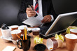 Businessman Stapling Papers at Messy Desk
