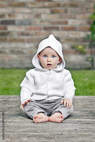 Photo: Pretty Baby Girl Sitting in Garden Pretty Baby Girl Sitting in Garden