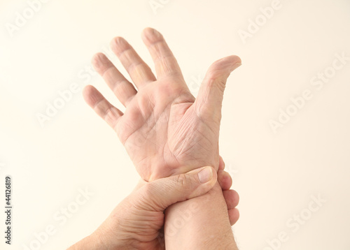 Photo: a man grips his painful wrist a man grips his painful wrist