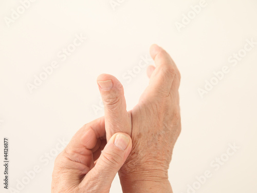 Photo: a man holds his aching thumb a man holds his aching thumb