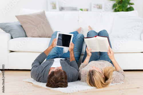 Photo: paar liest mit buch und tablet paar liest mit buch und tablet