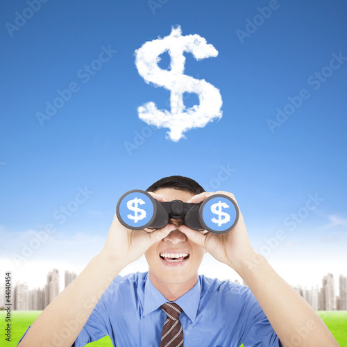 Photo: happy businessman holding binoculars and watching the money clou happy businessman holding binoculars and watching the money clou