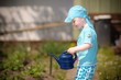Foto: Kind im Garten hat Spaß mit Gießkanne Kind im Garten hat Spaß mit Gießkanne