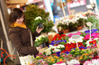 Photo: Beautiful young girl selecting flowers at flower market Beautiful young girl selecting flowers at flower market
