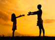 Silhouettes of mother and daughter meeting on the meadow