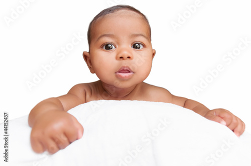 Photo: Baby peeping over the pillow in a white background Baby peeping over the pillow in a white background