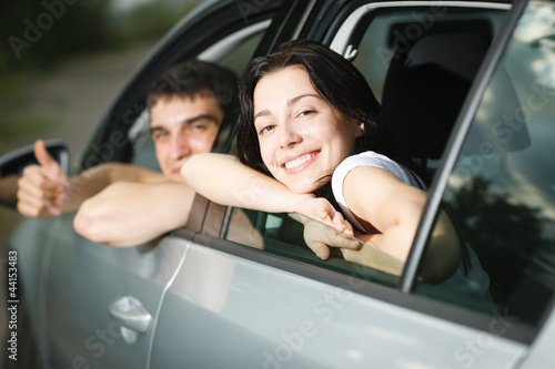 Photo: Beautiful happy young couple driving the car Beautiful happy young couple driving the car