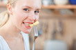 Foto: Woman tasting cooked macaroni in the kitchen, mac and cheese Woman tasting cooked macaroni in the kitchen, mac and cheese