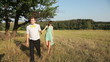 Young couple walking on the yellow grass