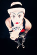 Circus clown in makeup with playing cards on a black background