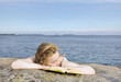 Portrait of a girl lying on the rock with book.