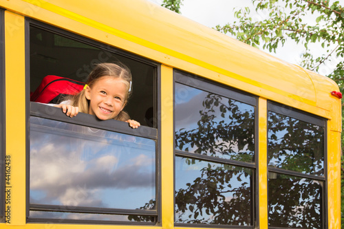 Photo: Little Schoolgirl looking through a Schoolbus Window Little Schoolgirl looking through a Schoolbus Window