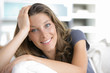 Portrait of a young woman smiling on white couch