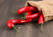 Red hot chili peppers in bag on wooden background
