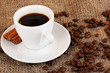 Cup of coffee on sacking on brown background