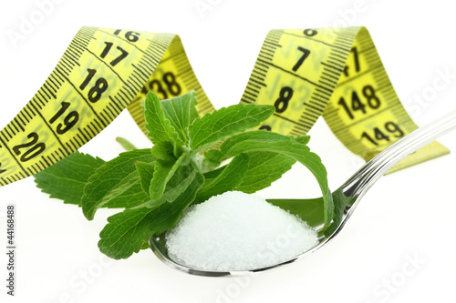 Photo: Fresh Stevia Rebaudiana, sugar in a spoon and measuring tape Fresh Stevia Rebaudiana, sugar in a spoon and measuring tape