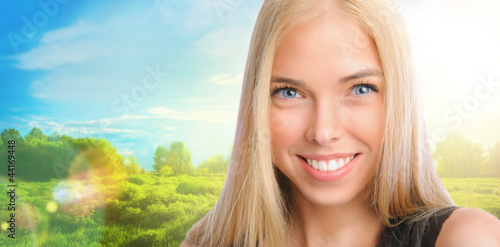 Photo: Young beautiful woman standing against idyllic landscape. Sunny Young beautiful woman standing against idyllic landscape. Sunny