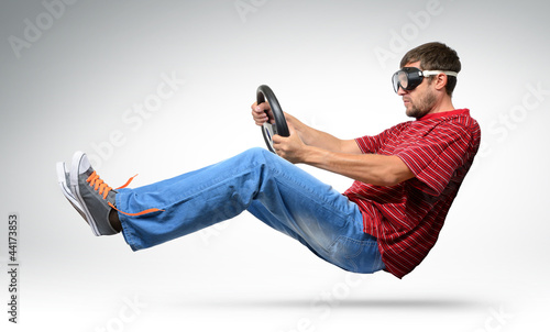 Photo: Unreal funny man car driver in goggles with a wheel Unreal funny man car driver in goggles with a wheel