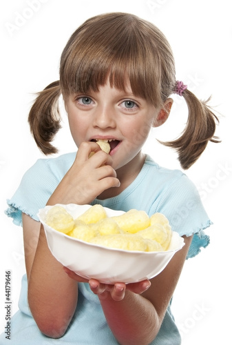 Photo: little girl eating corn snacks - white background little girl eating corn snacks - white background