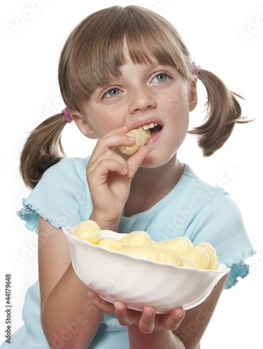 Photo: little girl eating corn nibbles isolated on white background little girl eating corn nibbles isolated on white background