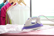 Electric iron and shirt, on cloth background