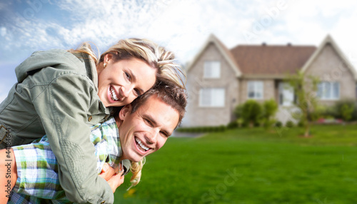 Photo: Happy family near new house. Happy family near new house.