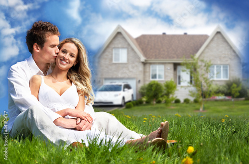 Photo: Happy family near new house. Happy family near new house.