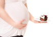 Pregnant woman hold a sweet cake on a plate.