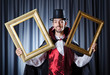 Magician with photoframe in studio